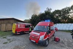 Sachsen / Bannewitz: Am 08.09.2025 kam es gegen 18.20 Uhr in Welschhufe zu einem Brand. In einem Waldstück zwischen der Horkenstraße und dem Hengstberg brannten ca. 120 Heuballen. Als die Feuerwehr eintraf, war die Rauchwolke schon aus der Entfernung zu sehen und die Ballen standen lichterloh in Flammen. Die Feuerwehrleute konnten zunächst verhindern, daß das Feuer auf die umliegende Natur übersprang und sich ausbreitete. Die Löschwasserversorgung war aufwändig und mußte über eine lange Wegstrecke aufgebaut werden. Später kamen zwei Radlader und ein Bagger zum Einsatz, um die Heuballen auseinanderzuziehen. Dann konnten die ca. 50 Feuerwehrleute den Brand löschen. Der Einsatz dauerte bis weit in die Nachstunden an, da die Löscharbeiten zeitintensiv waren. Im Einsatz waren die Freiwilligen Feuerwehren Bannewitz und Kreischa, sowie die Stadtteilfeuerwehr Kaitz. Die Polizei ermittelt zur Brandursache.