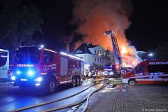 Sachsen / Rabenau: Am 14.05.2026 kam es gegen 20.50 Uhr in Oelsa zu einem Großbrand. An der Hauptstraße brannte ein ehemaliges Gebäude einer Polstermöbelfabrik. Aktuell soll das Gebäude fast leer gestanden haben. Einzig ein oder zwei Firmen sollen derzeit Mieter gewesen sein. Als die Feuerwehr eintraf, stand der Dachstuhl lichterloh in Flammen. Das Feuer breitete sich schnell auf das gesamte Gebäude aus. Die Rauchwolke war kilometerweit zu sehen. Schnell mußten weitere Kräfte nachalarmiert werden. Am Ende waren über 130 Feuerwehrleute der Freiwilligen Feuerwehren Rabenau, Freital, Bannewitz, Dippoldiswalde, Kreischa und Pirna im Einsatz. Zunächst gelang es, die umliegenden Häuser zu schützen. Mit mehreren Strahlrohren gelang es den Brand unter Kontrolle zu bringen. Erst nach mehreren Stunden konnte das Feuer gelöscht werden. Das DRK versorgte die Einsatzkräfte mit Essen und Getränken im nahen Gerätehaus der Freiwilligen Feuerwehr Rabenau. Die Hauptstraße in Oelsa war wegen des Einsatzes gesperrt. Die Polizei ermittelt zur Brandursache.