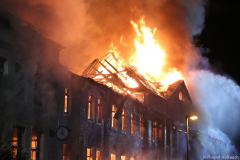 Sachsen / Rabenau: Am 14.05.2026 kam es gegen 20.50 Uhr in Oelsa zu einem Großbrand. An der Hauptstraße brannte ein ehemaliges Gebäude einer Polstermöbelfabrik. Aktuell soll das Gebäude fast leer gestanden haben. Einzig ein oder zwei Firmen sollen derzeit Mieter gewesen sein. Als die Feuerwehr eintraf, stand der Dachstuhl lichterloh in Flammen. Das Feuer breitete sich schnell auf das gesamte Gebäude aus. Die Rauchwolke war kilometerweit zu sehen. Schnell mußten weitere Kräfte nachalarmiert werden. Am Ende waren über 130 Feuerwehrleute der Freiwilligen Feuerwehren Rabenau, Freital, Bannewitz, Dippoldiswalde, Kreischa und Pirna im Einsatz. Zunächst gelang es, die umliegenden Häuser zu schützen. Mit mehreren Strahlrohren gelang es den Brand unter Kontrolle zu bringen. Erst nach mehreren Stunden konnte das Feuer gelöscht werden. Das DRK versorgte die Einsatzkräfte mit Essen und Getränken im nahen Gerätehaus der Freiwilligen Feuerwehr Rabenau. Die Hauptstraße in Oelsa war wegen des Einsatzes gesperrt. Die Polizei ermittelt zur Brandursache.